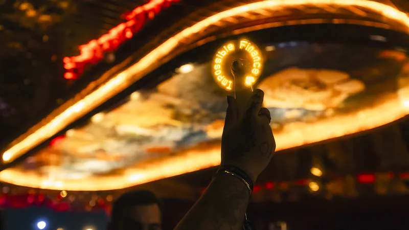 A light-up Impossible Finance fan held high
